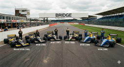 Sechs Minardi Formel 1 Rennwagen von 1985-1990 mit Fahrern auf einer Rennstrecke, mit Boxengebäuden und Tribünen im Hintergrund.