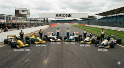 Sechs Minardi Formel-1-Wagen (1991-1996) mit Fahrern auf einer Rennstrecke, mit Boxengebäuden und Tribünen im Hintergrund.