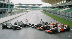 Fünf Formel-1-Fahrer und ihre McLaren-Mercedes-Rennwagen mit 'West'- und 'Vodafone'-Lackierung auf der feuchten Sepang-Rennstrecke.